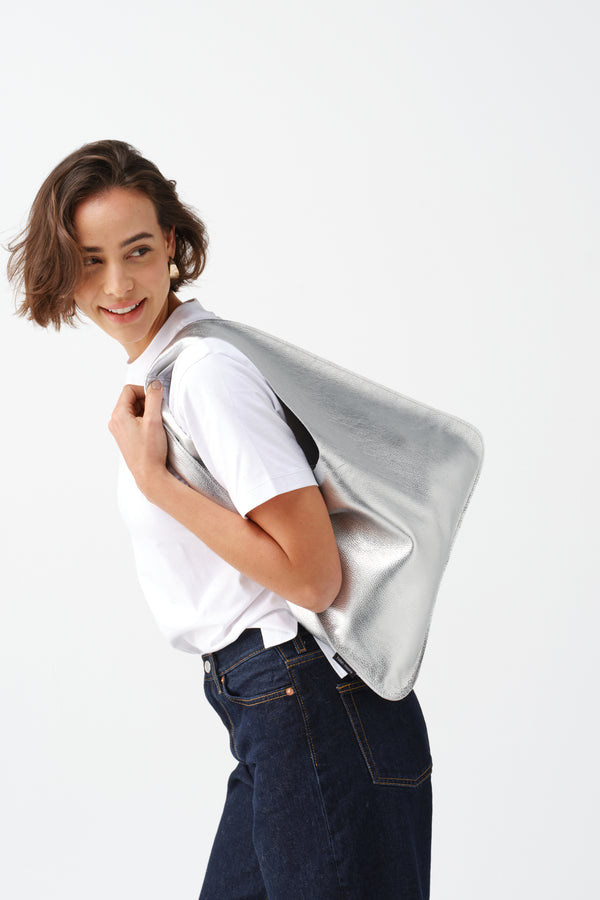 Model carrying the silver leather Triangle Bag by Helen Moore